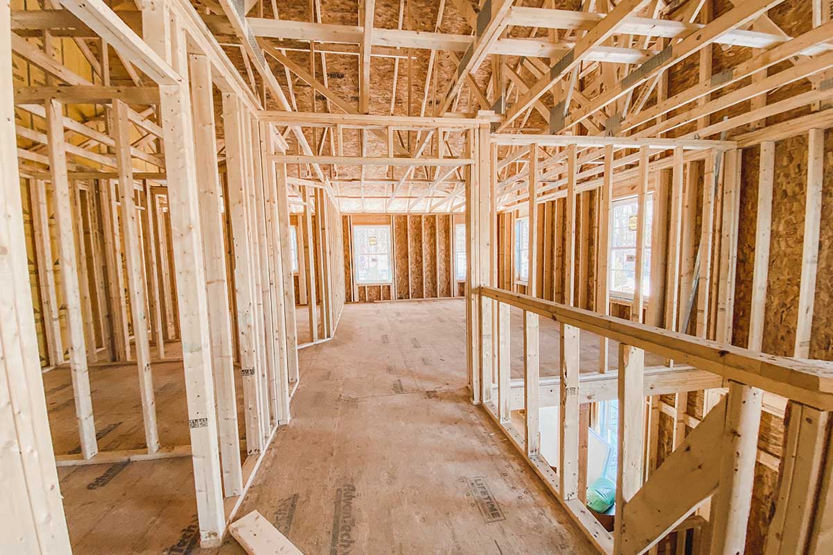 New house under construction with wooden framing in progress.